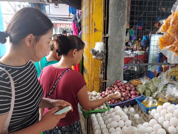 ▲ 코로나바이러스가 확산되기 직전, 필리핀 나가(Naga)시에 상주하며 카이나 프로젝트에 참여했던 한양대학교 공민영 학생이 사람들로 활기가 넘치는 시장에서 나나이 'Amy'와 함께 식재료를 구입하고 있다. 이렇게 직접 구입한 식료품으로 만든 김치볶음밥, 계란말이, 양념치킨 등은 카이나 식당의 인기메뉴였다. ⓒ 카이나
