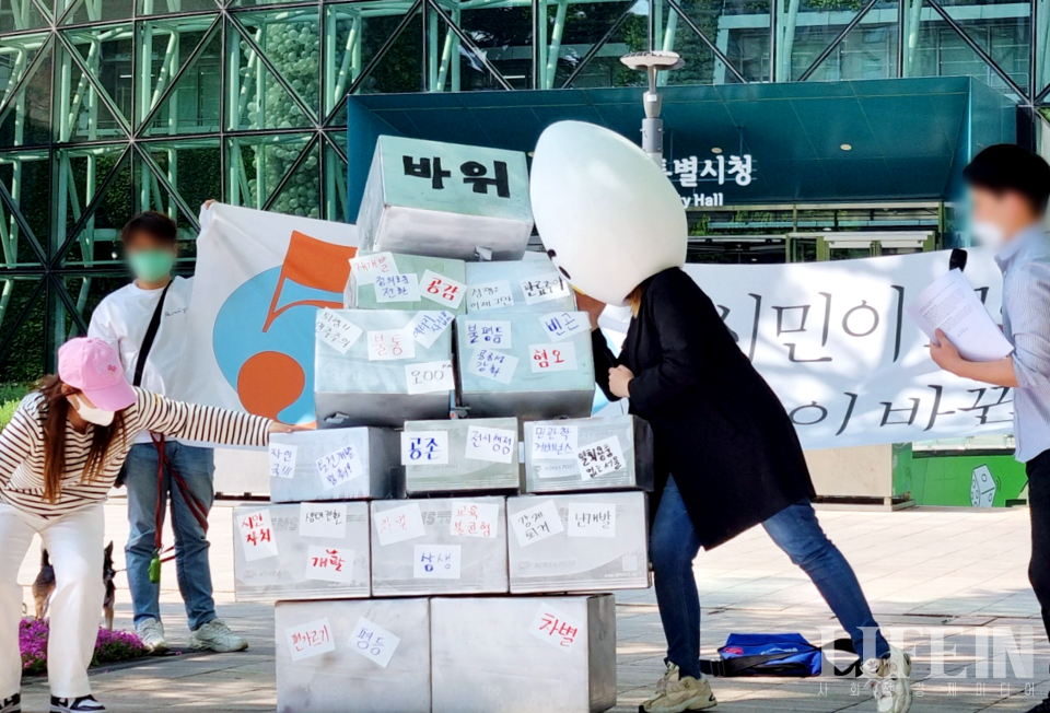 ▲ 이정도 후보가 '계란으로 바위 치기' 퍼포먼스를 진행하고 있다. 바위 모양의 구조물에는 서울시에서 지켜야 할 것들과 서울시에서 사라져야 할 것들이 각각 적혀 있다. ⓒ라이프인