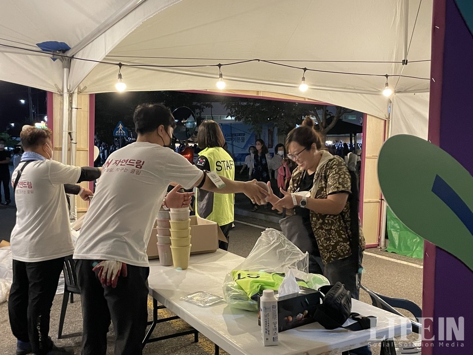 ▲ 주최 측 자연드림 관계자가 퇴장하는 관객에게 플라스틱 재활용 화분을 증정하고 있다. ⓒ라이프인