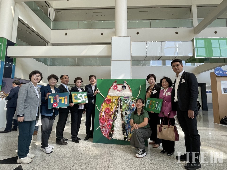 ▲ 김강은 작가(초록색 상의)의 폐품활용예술작품과 함께 염태영 경기도 경제부지사(작품 바로 왼쪽)를 비롯한 행사 내빈들이 사진을 촬영하고 있다. ⓒ라이프인