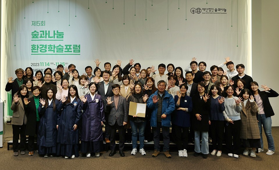 (재)숲과나눔 제5회 환경학술포럼 참가자들이 무대에 모여 단체사진을 찍고 있다.