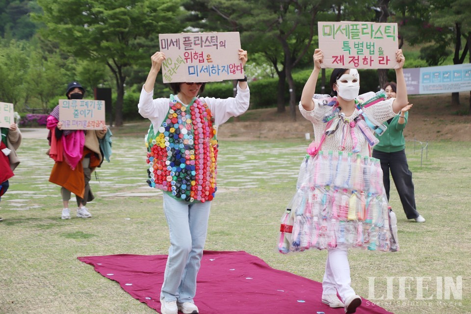 ▲활동가들이 지구의 날을 맞아 버려진 플라스틱 병과 뚜껑을 활용해 만든 플라스틱 드레스를 선보이고 있다. ⓒ라이프인