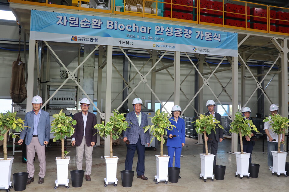 ▲ 자원순환 시스템 구축을 기념하며 생산된 Biochar를 비료로 나무에 주는 퍼포먼스를 하고 있다.왼쪽으로부터 김용복 서안성농협 원곡지점장, 이호철 4EN 대표, 안정열 안성시의회 의장, 김보라 안성시장 (전국 사회연대경제 지방정부협의회 사무총장), 박건후 NH투자증권 Client솔루션본부 대표, 안성시 시니어클럽 노인일자리 참여 대표, 안성시 지역카페 대표.