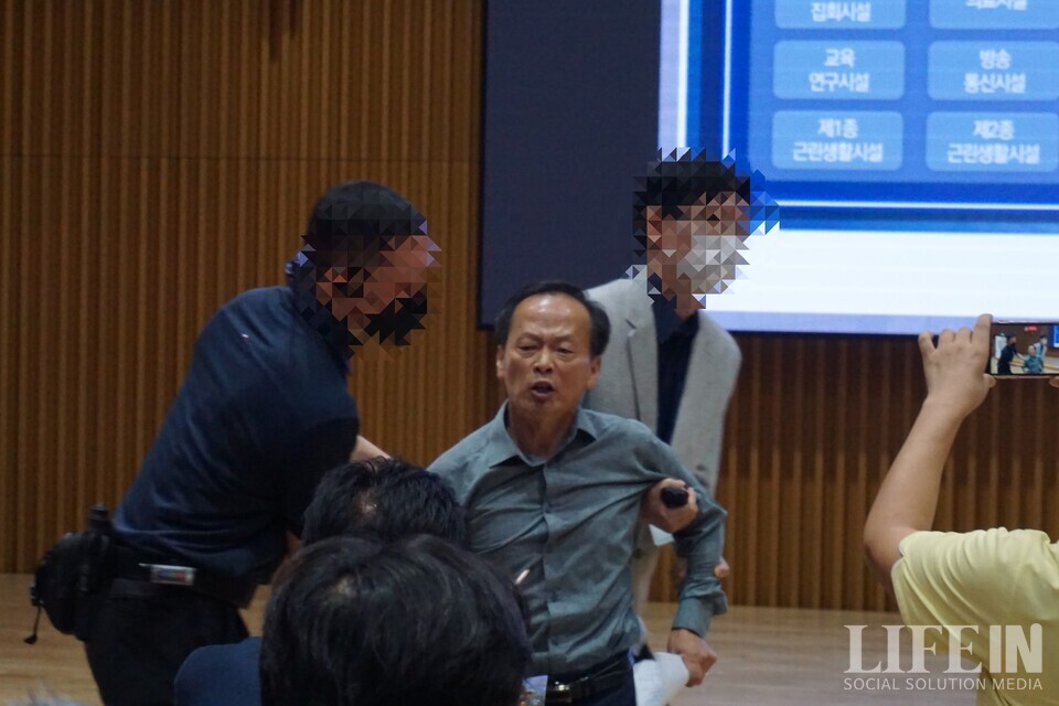 ▲ 서울시 공무원이 '서울창조타운 조성 기업설명회'에서 '서울혁신파크' 부지 매각을 막으려는 시민활동가( 최승국 태양과바람에너지협동조합 이사장)를 끌고 나가고 있다. ⓒ라이프인 