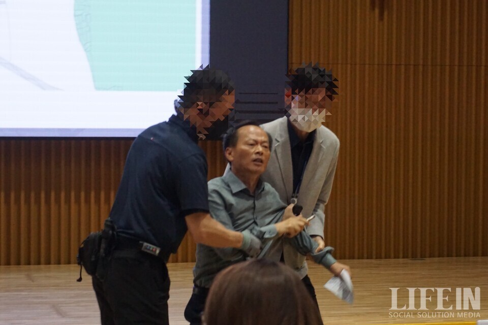 ▲ 서울시 공무원이 '서울창조타운 조성 기업설명회'에서 '서울혁신파크' 부지 매각을 막으려는 시민활동가( 최승국 태양과바람에너지협동조합 이사장)를 끌고 나가고 있다. ⓒ라이프인 