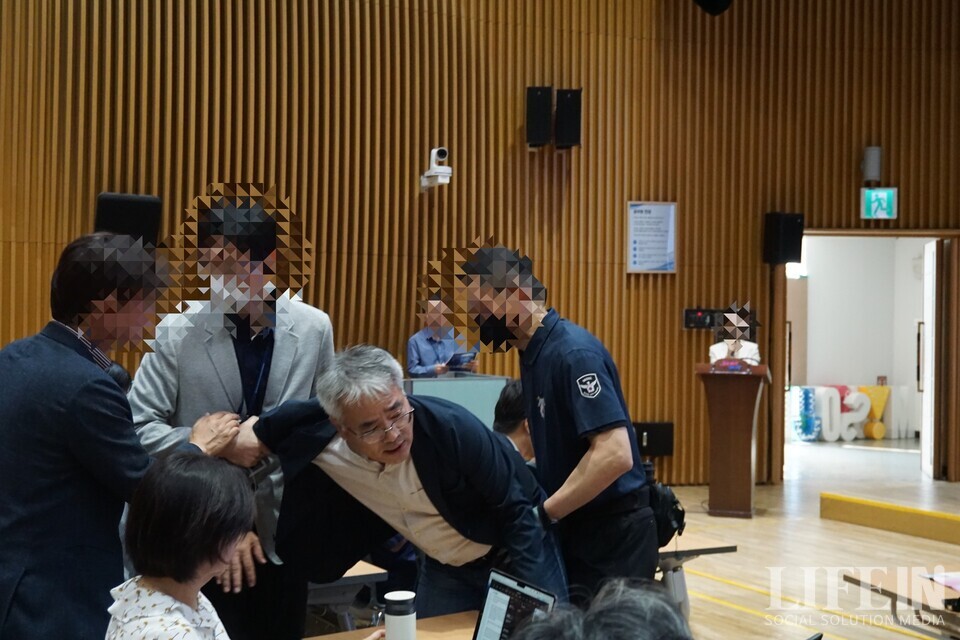 ▲ 서울시 공무원들이 '서울창조타운 조성 기업설명회'에서 '서울혁신파크' 부지 매각을 막으려는 시민활동가(김종민 서울네트워크 공동상황실장)를 제지하고 있다. ⓒ라이프인 