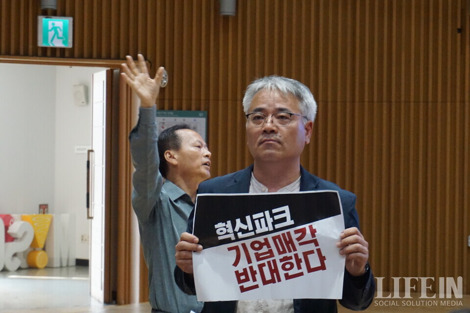 ▲ 혁신파크 공공성을 지키는 서울네트워크 소속 시민활동가들. (왼쪽)최승국 태양과바람에너지협동조합 이사장이 사회자에게 발언권을 요청하고 있다. ⓒ라이프인