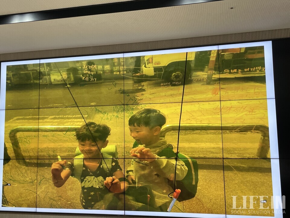 ▲ 경기도 안산시 석수초등학생들이 지역 주민들의 쓰레기 투척 문제를 막기 위해 설치한 임시 담벼락에 메시지를 적고 있다. ⓒ라이프인